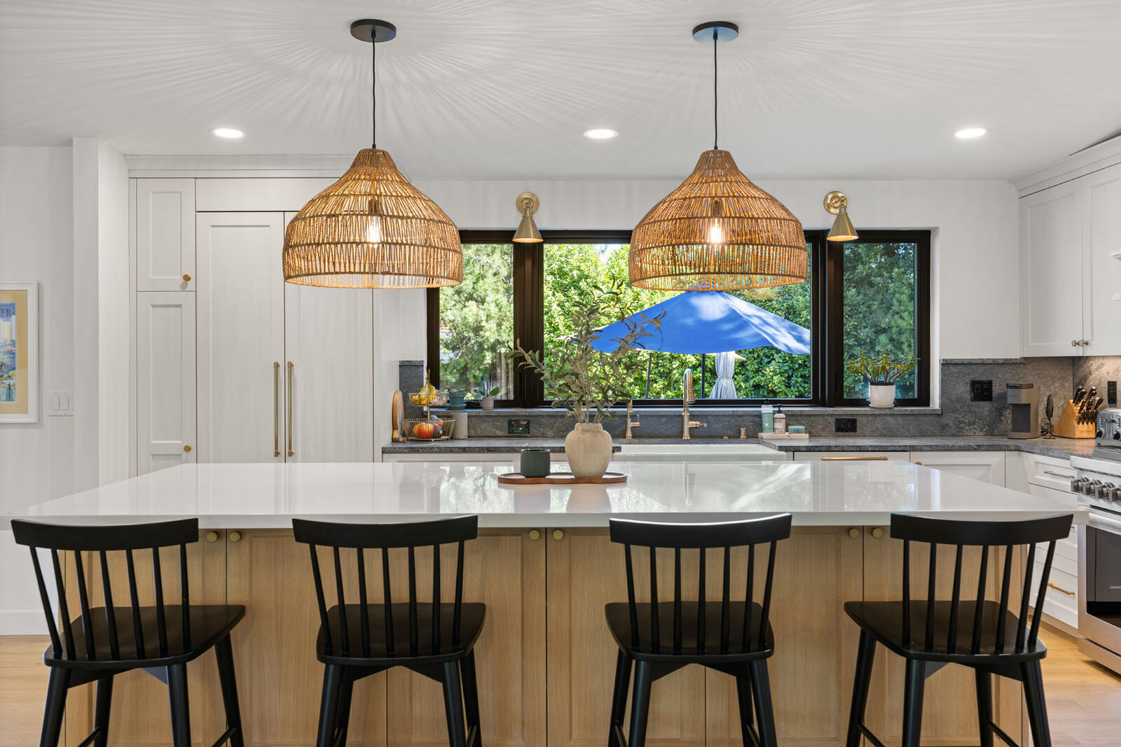 Remodeled Sacramento, CA kitchen with white cabinets, black chairs, and a beautiful island