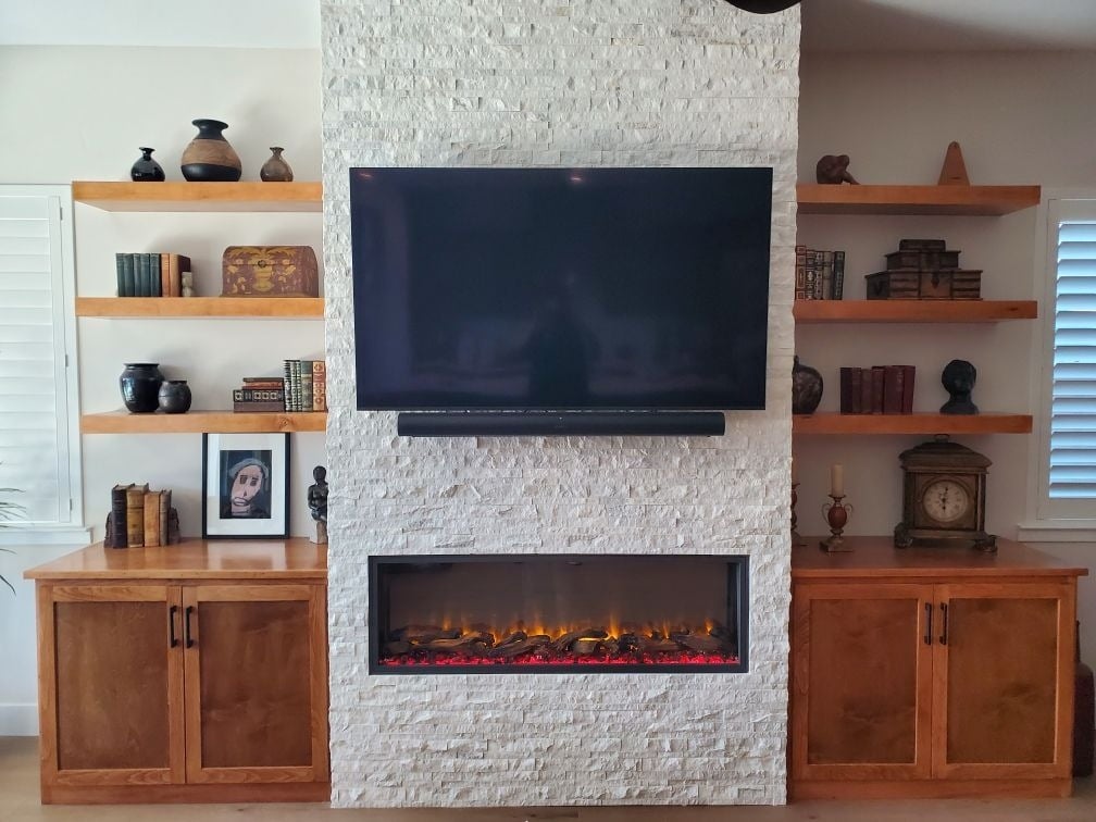 Custom living room remodel with a white stacked stone fireplace, wooden cabinets, and modern decor by H&H Builds in Sacramento, CA