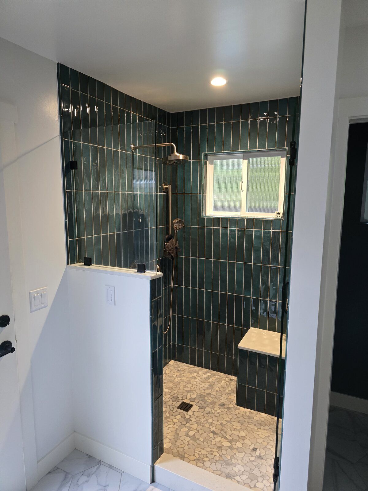 Walk-in shower remodel with green tile walls, bench seating, and window by H&H Builds, Sacramento, CA