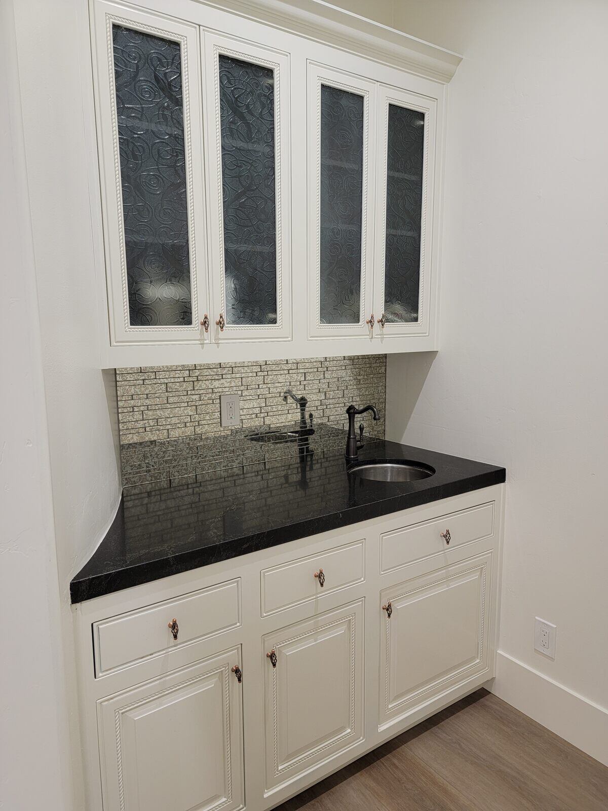 Small kitchen nook with custom white cabinetry and black countertop by H&H Builds in Sacramento, CA