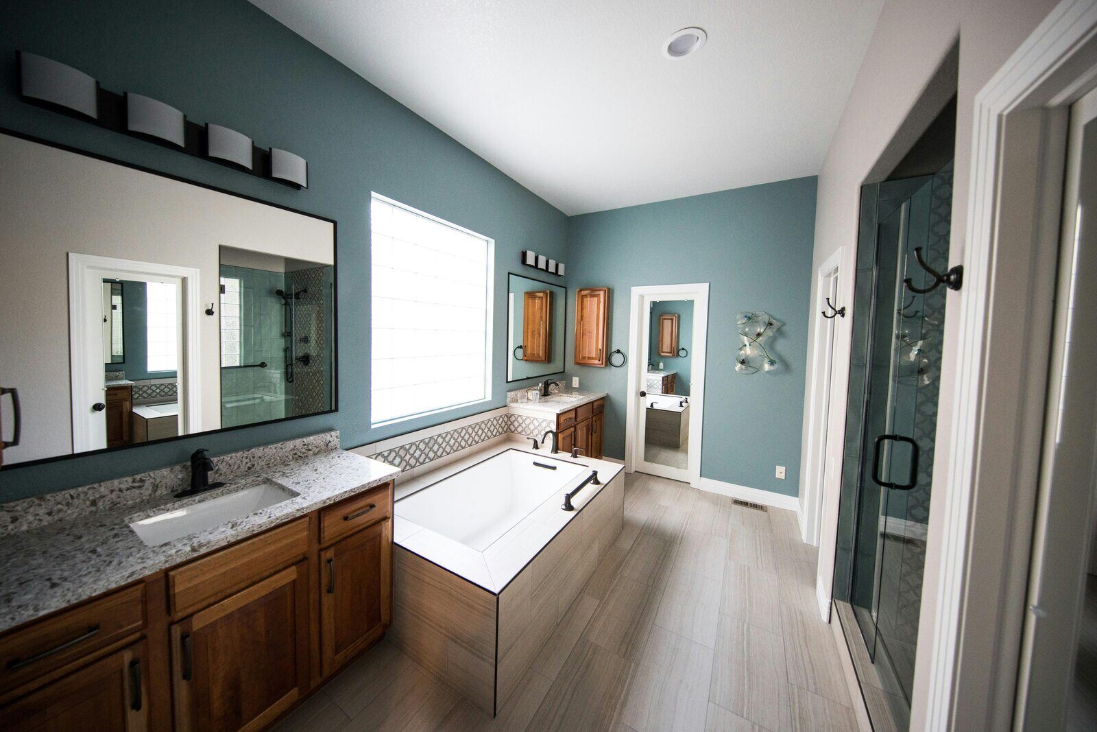 Modern master bathroom remodel by H&H Builds in Sacramento, CA, featuring a standalone bathtub, double vanity, and glass shower