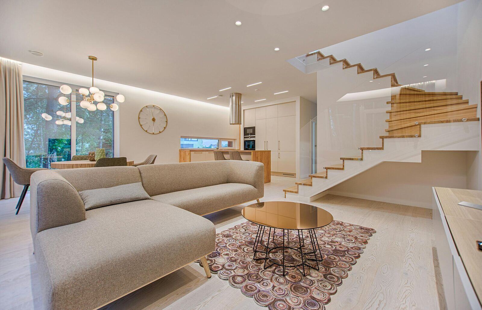 Modern open-concept living space featuring neutral tones, wood finishes, and a sleek staircase by H&H Builds in Sacramento, CA