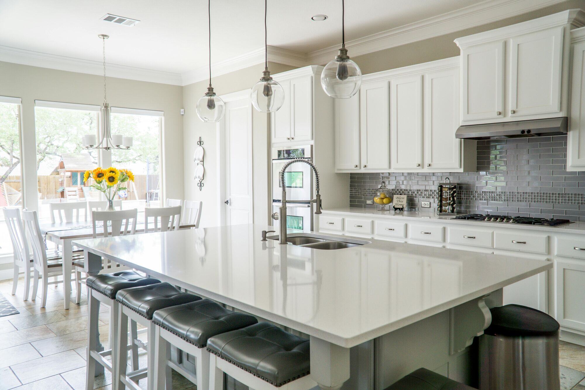 Bright modern kitchen remodel with white cabinets, large island, and pendant lighting by H&H Builds in Sacramento, CA