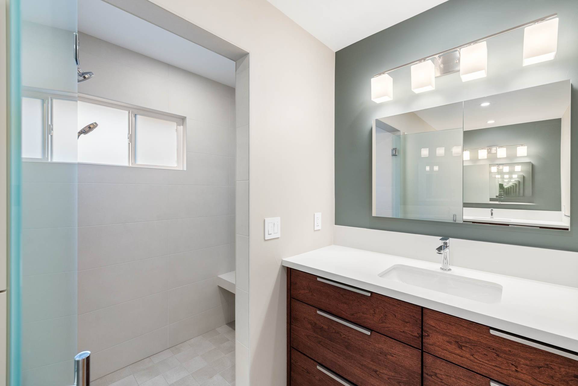 Open shower with bench and frosted windows in a modern Sacramento bathroom